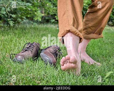 Barfuß gehen, Erdung und Erdung Konzept - Füße von Senior Mann auf dem Gras. Gesundheit, Verjüngung und Entspannung. Stockfoto