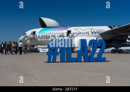 ILA22 Hashtag auf dem Flugplatz. Im Hintergrund ist ein Großraumflugzeug des Typs Airbus A350-900 XWB zu sehen. Ausstellung ILA Berlin Air Show 2022 Stockfoto