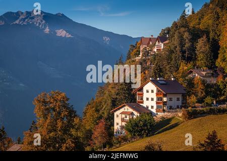 Hafling, Italien - traditionelle tiroler Häuser in Hafling - Hafelengo bei einem warmen Herbstuntergang mit den italienischen Dolomiten in Südtirol im Hintergrund Stockfoto