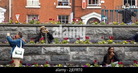 Dublin, Irland - 3. Juni 2022: Menschen, die sich auf der Bank im Garten des Gedenkens in Dublin, Irland, ausruhen Stockfoto