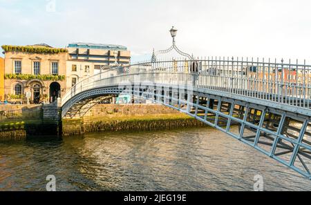 Dublin, Irland - 4. Juni 2022: Ha'Penny Bridge und offiziell die Liffey Bridge, eine Fußgängerbrücke, die im Mai 1816 über den Fluss Liffey gebaut wurde Stockfoto