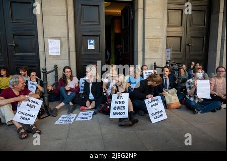 Berlin, Deutschland. 27.. Juni 2022. Aktivisten sitzen vor dem Finanzministerium und demonstrieren unter anderem für globalen Schuldenerlass und Klimagerechtigkeit. Quelle: Christophe Gateau/dpa/Alamy Live News Stockfoto