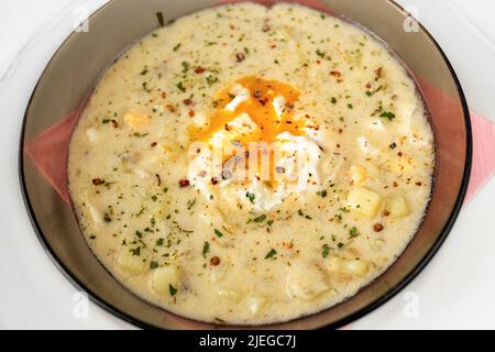 Kartoffelsuppe 'kulajda' mit Ei in brauner Platte, Nahauflagefläche. Traditionelle tschechische Suppe. Stockfoto