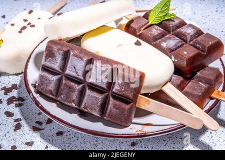 Schokolade- und Vanillepopsicles, klassischer dunkelbrauner Kakao und Milcheis-Lolly-Pops. Stapel von verschiedenen Eis-Lollies flach Draufsicht CO Stockfoto