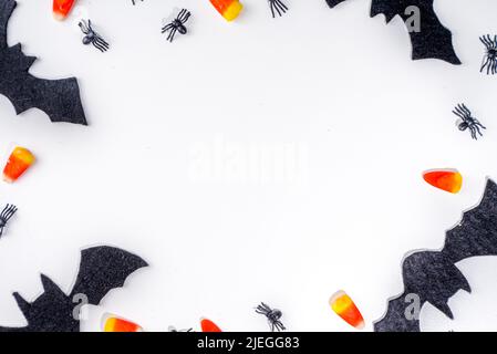 Halloween Rahmen Hintergrund. Fledermaus- und Spinnendekorationen mit traditionellem Trick o Treat Candy Corn auf weißem Hintergrund. Halloween Grußkarte. Flat la Stockfoto