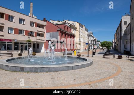 Ciechanow, Masovia, Polen - 5. Juni 2022: Platz mit Brunnen in der Warszawska Straße im Stadtzentrum. Stockfoto