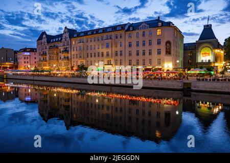 Berlin, Deutschland - 8. August 2021: Innenstadt mit Spree am Abend, Gebäude am Schiffbauerdamm mit Restaurants, Cafés i Stockfoto