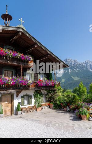 Ellmau, Österreich - Juni 19: Traditionelles Holzhaus in der Serie Bergdoktor und Wilder Kaiser im Hintergrund Stockfoto