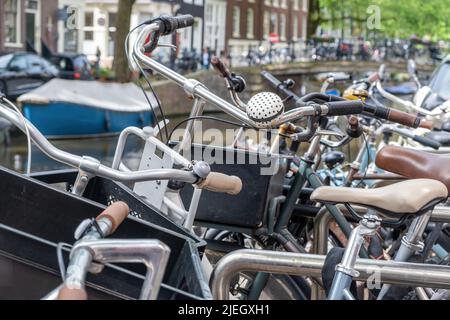 Fahrräder geparkt Hintergrund. Parkplätze für Fahrräder im Stadtzentrum von Amsterdam, Nahaufnahme. Traditionelles Transportfahrzeug. Niederlande Holland Stockfoto