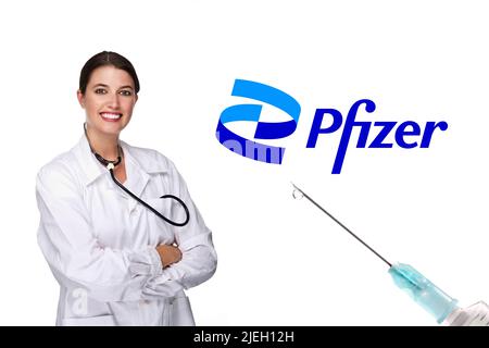 Junge Ärztin mit Stethoskop und Tabletten in der Hand, 30, 35, Jahre, brünet, Sommersprossen, neues Pfizer Logo, Impfstoff, Hersteller, Stockfoto