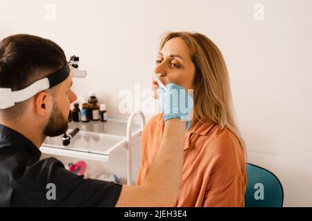 Rhinoskopie der weiblichen Nase. Rücksprache mit dem Arzt. Der Otolaryngologe untersucht die Nase des Mädchens vor der Endoskopie der Nase Stockfoto