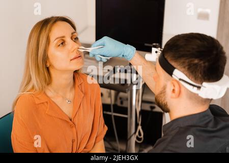 Rhinoskopie der weiblichen Nase. Rücksprache mit dem Arzt. Der Otolaryngologe untersucht die Nase des Mädchens vor der Endoskopie der Nase Stockfoto