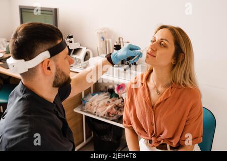 Rhinoskopie der weiblichen Nase. Rücksprache mit dem Arzt. Der Otolaryngologe untersucht die Nase des Mädchens vor der Endoskopie der Nase Stockfoto