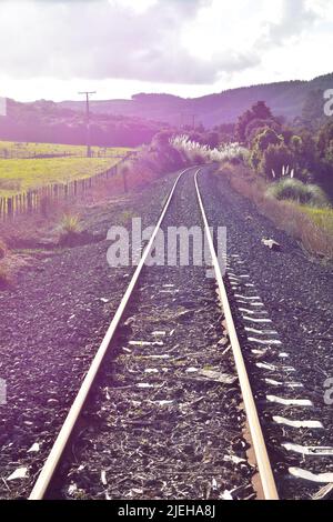 Ungenutzte Bahngleise entlang des eingezäunten Fahrerlagers in der neuseeländischen Landschaft. Ort: Rodney District New Zealand Stockfoto