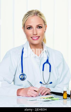 Eine junge blonde Ärztin bei der Ordination in ihrer Arztpraxis. Stockfoto