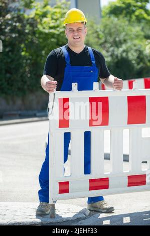 Arbeiter überwacht die Baustellenabsperrung , gelber Schutzhelm, Mann, 35, 40, Bauarbeiter, berufs, Berufes, Stockfoto