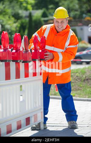 Arbeiter überwacht die Baustellenabsperrung , gelber Schutzhelm, Mann, 35, 40, Bauarbeiter, berufs, Berufes, Stockfoto