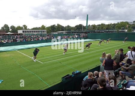 Die Bodenmitarbeiter bringen die Abdeckungen des Platzes wegen Regen am Tag einer der Wimbledon Championships 2022 im All England Lawn Tennis and Croquet Club, Wimbledon. Bilddatum: Montag, 27. Juni 2022. Stockfoto