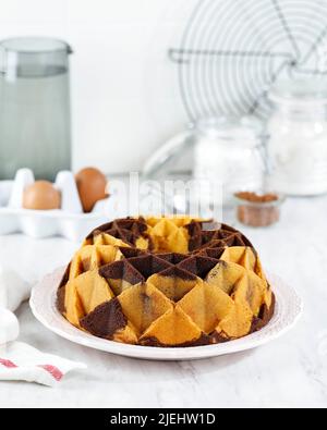 Marble Bundt Cake, Butterkuchen mit Vanille und Schokoladenteig auf Holztisch. White Bakery Konzept Stockfoto