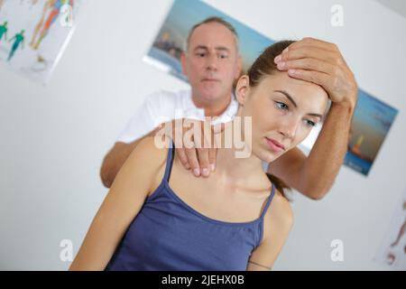 Physiotherapeutin, die weibliche Patientin in der Klinik eine Nackenmassage gibt Stockfoto