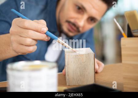 Junger Mann, der in der Klasse Töpferwaren dekorieren kann Stockfoto