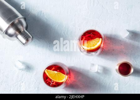 Orangencocktails von Campari mit Jigger und Shaker, sommerliche Party-Drinks auf Eis mit Kopierfläche, von oben geschossen Stockfoto