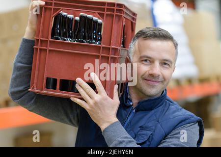 Porträt eines Mannes, der eine Kiste Bier trägt Stockfoto