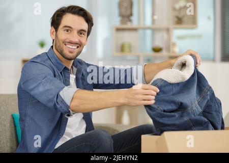 Mann, der ein Paket öffnet Stockfoto