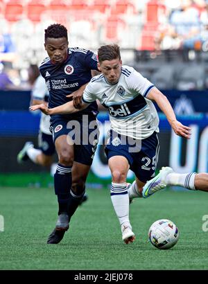 (220627) -- VANCOUVER, 27. Juni 2022 (Xinhua) -- Wilfrid Kaptoum (L) der New England Revolution wetteifert mit Ryan Gauld von Vancouver Whitecaps während des Spiels der Major League Soccer (MLS) 2022 auf dem BC Place in Vancouver, Kanada, am 26. Juni 2022. (Foto von Andrew Soong/Xinhua) Stockfoto