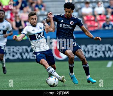 (220627) -- VANCOUVER, 27. Juni 2022 (Xinhua) -- Marcus Godinho (L) von Vancouver Whitecaps (Vancouver) steht während des Spiels der Major League Soccer (MLS) 2022 am BC Place in Vancouver, Kanada, am 26. Juni 2022 mit Dylan Borrero der New England Revolution im Spiel. (Foto von Andrew Soong/Xinhua) Stockfoto