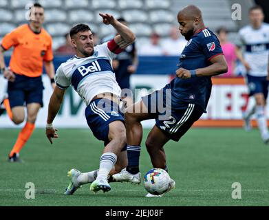 (220627) -- VANCOUVER, 27. Juni 2022 (Xinhua) -- Lucas Cavallini (L) von Vancouver Whitecaps (Vancouver) steht während des Spiels der Major League Soccer (MLS) 2022 am BC Place in Vancouver, Kanada, am 26. Juni 2022 mit Andrew Farrell, dem New England Revolution, im Spiel. (Foto von Andrew Soong/Xinhua) Stockfoto