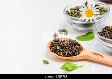 Sorten von hochwertigem schwarzen oder roten und grünen Tee, chinesischen Oolong-Tee mit Ginseng, gebrühten Tee in Tasse. Teesortiment im Geschäft. Weißer Hintergrund. Stockfoto