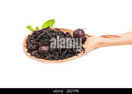 Hochwertiger roter Tee mit Beeren von schwarzer Johannisbeere. Stapel schwarzen Tees in einem Holzlöffel. Teesortiment im Geschäft. Chinesisch oder orientalisch gesund, wärmend te Stockfoto