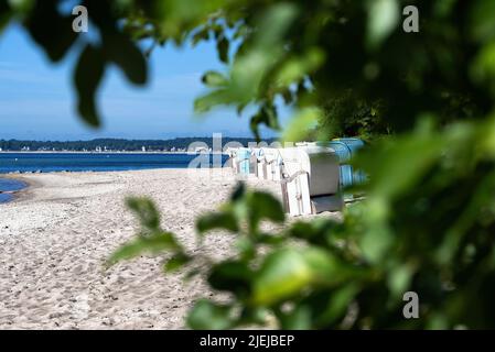 Traditionelle Strandliegen am ostseestrand vor blauem Himmel am sonnigen Sommertag Stockfoto