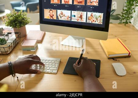 Nahaufnahme eines Retuschers mit einem Grafiktablett zum Retuschieren von Fotos auf dem Computermonitor am Tisch Stockfoto