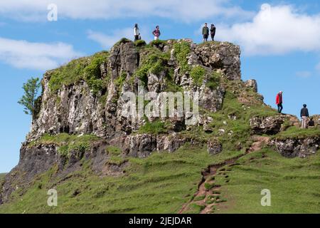 Touristen im Fairy Glen auf der Halbinsel Trotternish. Abwechslungsreiche Landschaft mit Hügeln, Tälern und Basaltklippen im Norden von Skye. Gebiet leidet unter Übertourismus. Stockfoto