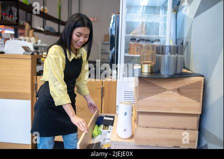 Frau öffnet die Schublade am Arbeitsplatz Stockfoto