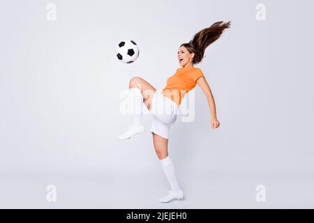 Ganzkörper-Foto von erfahrenen Dame Fußball-Nationalspieler Euro 2020 Ligaspiel nehmen Ball auf dem Knie zeigen Trick tragen Fußball Uniform T-Shirt Shorts Stollen Stockfoto