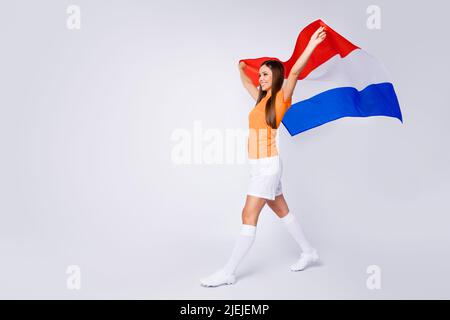 In voller Größe Profilfoto der sportlichen freudigen Dame unterstützen Fußballteam 2020 Cup halten nationalen niederlande Flagge gehen singen Hymne tragen Fußball-T-Shirt Stockfoto