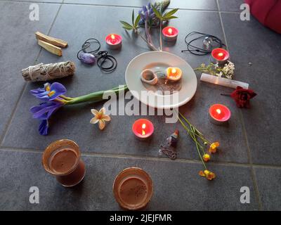 Roher Kakao mit Blumenkerzen, Federn, Palo Santo, Lorbeerblättern und Kissen für die schamanische Zeremonie Stockfoto