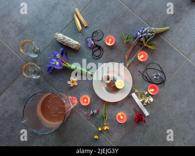 Roher Kakao mit Blumenkerzen, Federn, Palo Santo, Lorbeerblättern und Kissen für die schamanische Zeremonie Stockfoto