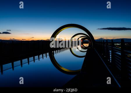 Falkirk, Großbritannien - 19. Juni 2022: Blick auf das Falkirk Wheel bei Sonnenuntergang mit Lichtern in verschiedenen leuchtenden Farben Stockfoto