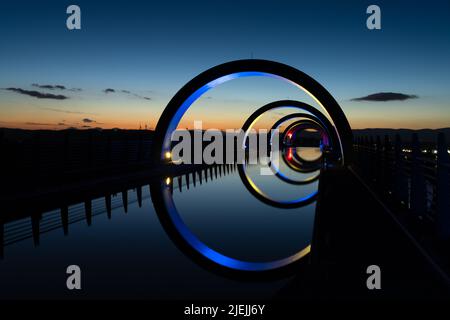 Falkirk, Großbritannien - 19. Juni 2022: Blick auf das Falkirk Wheel bei Sonnenuntergang mit Lichtern in verschiedenen leuchtenden Farben Stockfoto