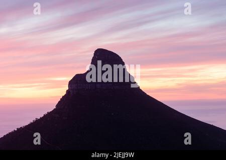 Die leuchtend roten und orangen Wolken verblassen mit dem Sonnenuntergang über der beliebten Touristenattraktion Lions Head, Kapstadt, Südafrika. Stockfoto