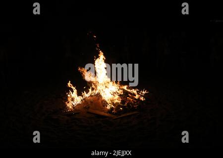 Holzfeuer am Strand. Sonnenwende-Feier in Spanien Stockfoto