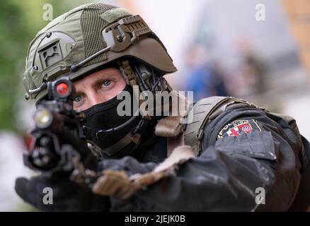 Mainz, Deutschland. 27.. Juni 2022. Ein Offizier des Sondereinsatzkommandos (SEK) der Rheinland-pfälzischen Polizei nimmt während einer Übung mit seiner Waffe bereit Stellung ein. Der SEK ist auf vier Standorte in Rheinland-Pfalz verteilt. Quelle: Boris Roessler/dpa/Alamy Live News Stockfoto