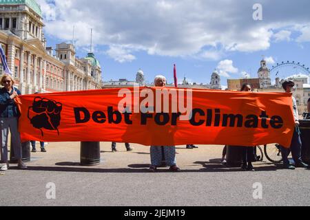 London, Großbritannien. 26.. Juni 2022. Aktivisten der Extinction Rebellion bei der Horse Guards Parade. Die Aktion war Teil der Proteste und des marsches des Tages, in denen gefordert wurde, dass die G7 die Schulden der Länder im globalen Süden streichen, was die Nationen zwingt, fossile Brennstoffe zu extrahieren, um die Schulden zu bezahlen. Stockfoto