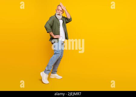 In voller Länge Körpergröße Foto von älteren Mann in stilvoller Kleidung tanzen auf Party isoliert lebendige gelbe Farbe Hintergrund mit Copyspace Stockfoto