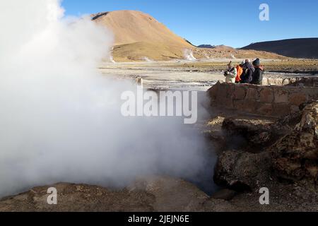 Touristen besuchen die Geysire El Tatio, Chile. El Tatio ist ein Geysir-Feld im Norden Chiles. Es ist das größte Geysir-Feld im Sou Stockfoto