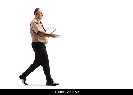 In voller Länge Profilaufnahme eines reifen Sicherheitsbeamten zu Fuß und hält eine Taschenlampe isoliert auf weißem Hintergrund Stockfoto